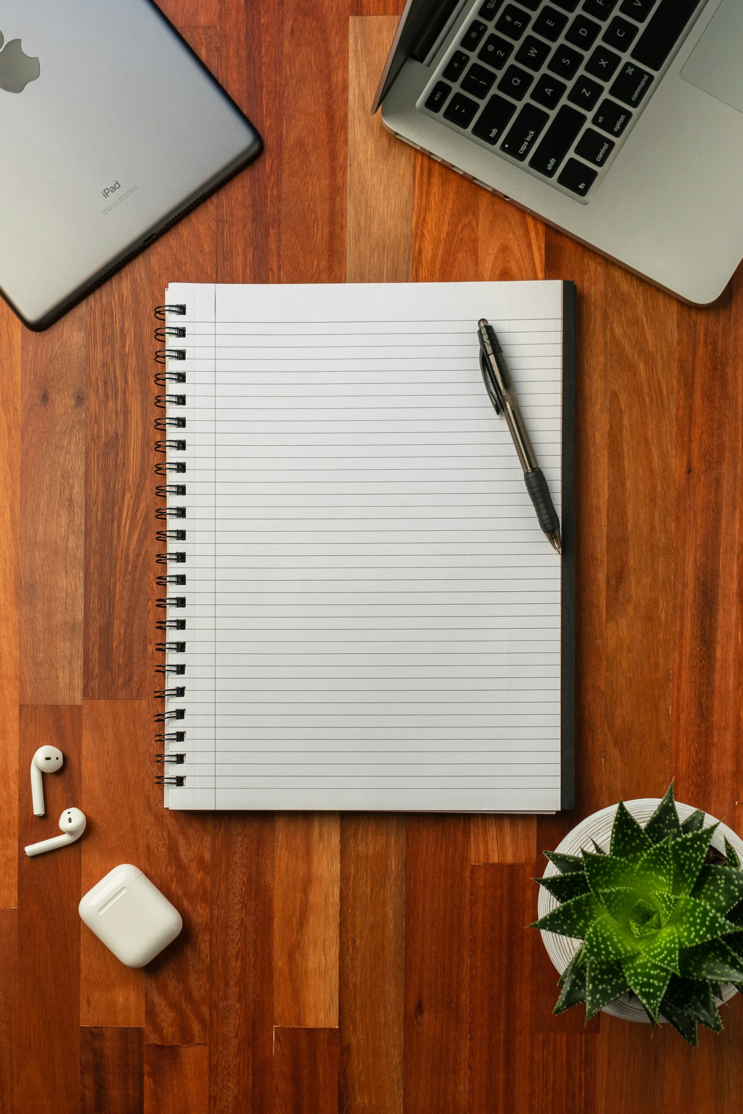 A black pen resting on an open white notebook